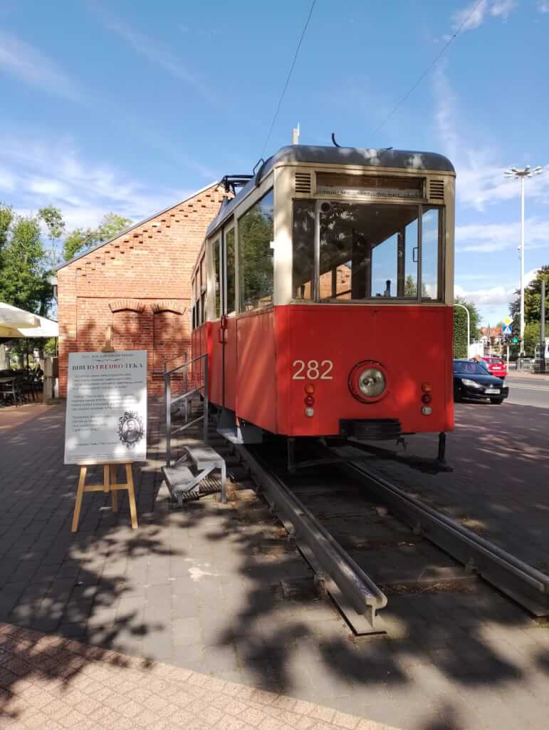 Tablica z cytatami Fredry przy zabytkowym tramwaju